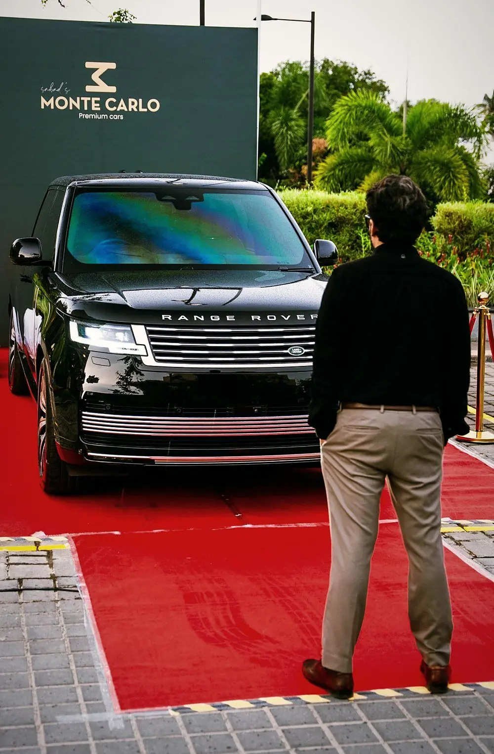 Sabad looking at a Range Rover presented beneath the Monte Carlo sign